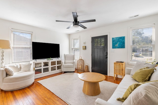 living area with visible vents, hardwood / wood-style flooring, and a ceiling fan