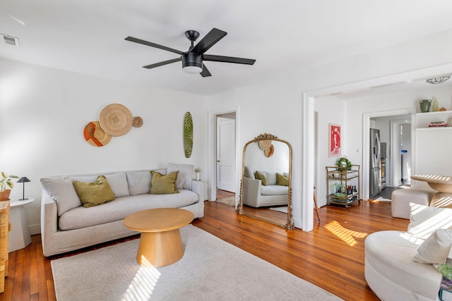 living area with ceiling fan, wood-type flooring, and visible vents