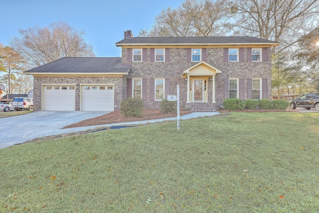 colonial inspired home with a garage and a front lawn