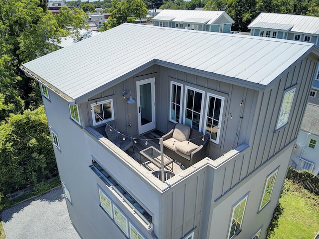 exterior space with board and batten siding, metal roof, and a standing seam roof