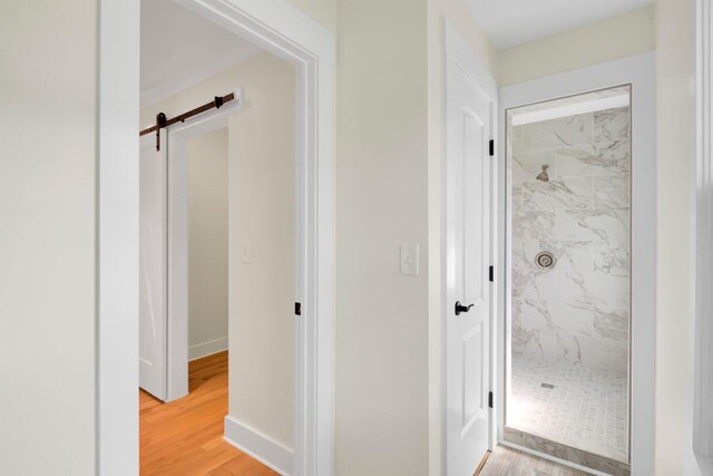 8612 Delhi Rd, North Charleston, SC 29406 - hallway with a barn door, light wood-style flooring, and baseboards