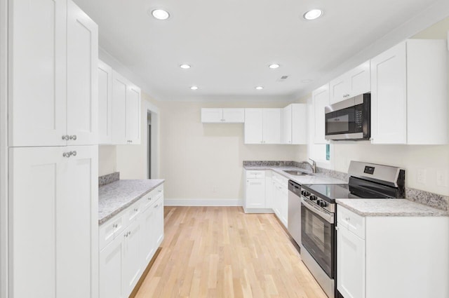 8612 Delhi Rd, North Charleston, SC 29406 - kitchen featuring appliances with stainless steel finishes, a sink, baseboards, white cabinetry, and light wood finished floors