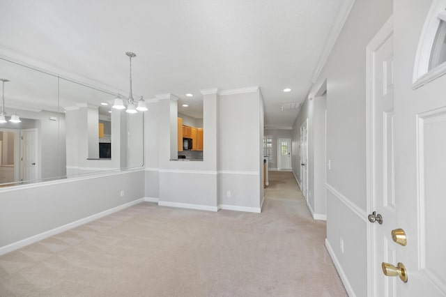 unfurnished room featuring light colored carpet, ornamental molding, and an inviting chandelier