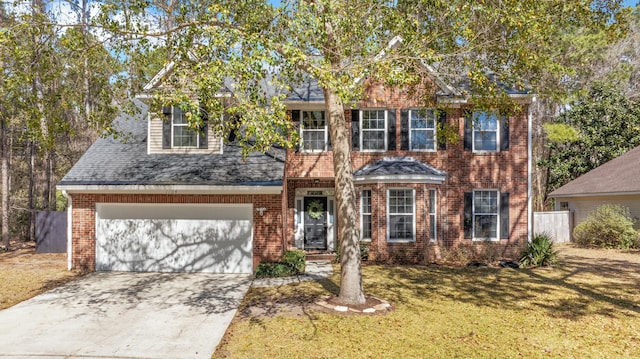 colonial inspired home featuring concrete driveway, brick siding, a garage, and a front yard