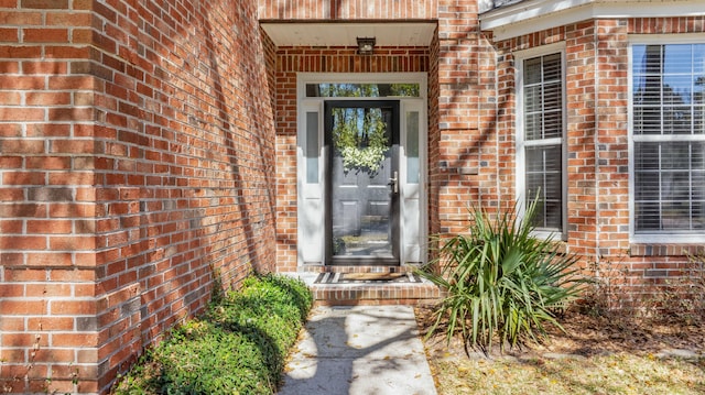 entrance to property featuring brick siding