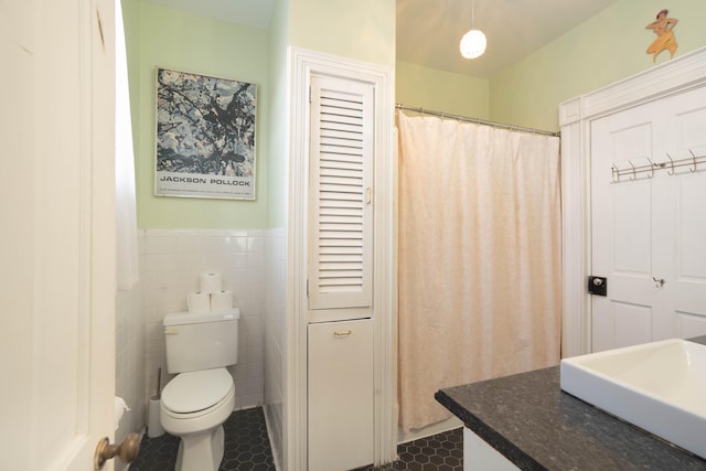 bathroom with tile patterned floors, sink, tile walls, and toilet