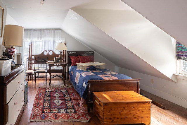 bedroom featuring hardwood / wood-style floors and lofted ceiling