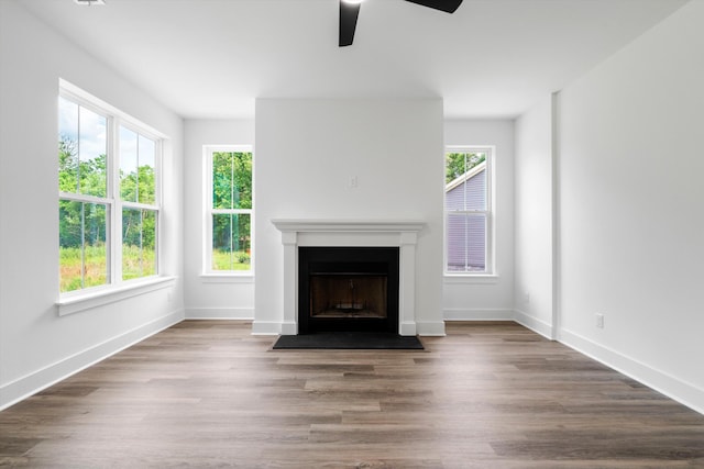 1076 Williams Rd, Charleston, SC 29412 - unfurnished living room featuring a ceiling fan, plenty of natural light, a fireplace with flush hearth, and wood finished floors