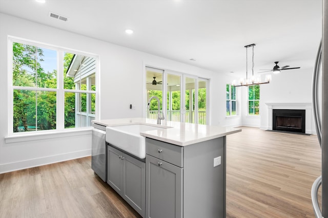 1076 Williams Rd, Charleston, SC 29412 - kitchen featuring gray cabinetry, a sink, appliances with stainless steel finishes, a center island with sink, and light countertops