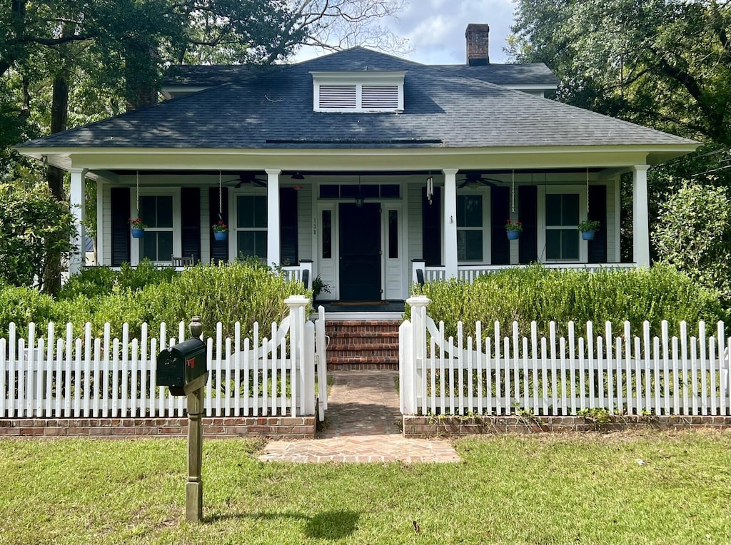 bungalow-style house featuring covered porch and a front yard