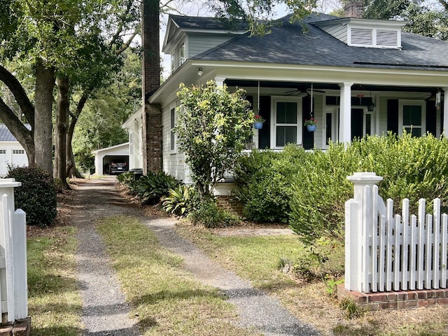 view of home's exterior featuring ceiling fan, an outdoor structure, a porch, and a garage