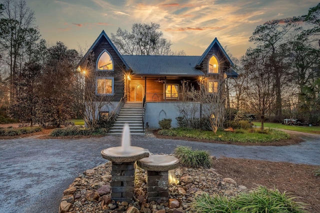 chalet / cabin featuring stairs and covered porch