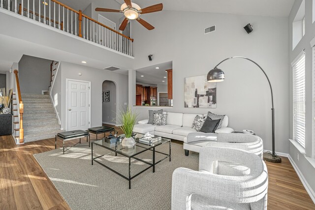 living room featuring light hardwood / wood-style floors, high vaulted ceiling, and ceiling fan