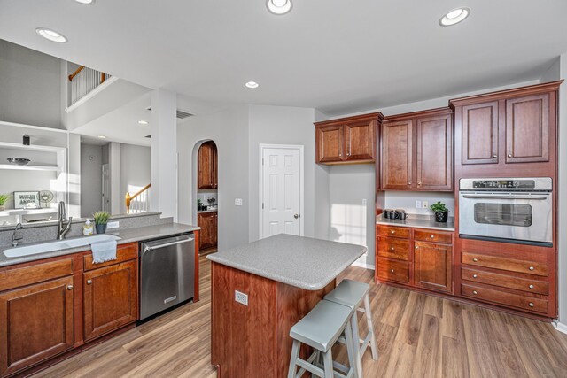 kitchen featuring light tile patterned flooring, kitchen peninsula, a kitchen bar, a kitchen island, and appliances with stainless steel finishes