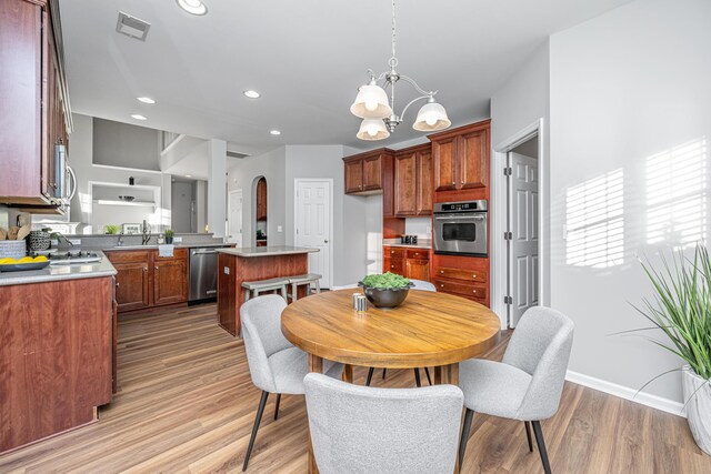 kitchen with a kitchen bar, appliances with stainless steel finishes, sink, a kitchen island, and light tile patterned flooring