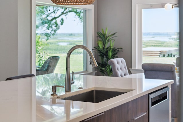 kitchen featuring a sink, light countertops, modern cabinets, and stainless steel dishwasher