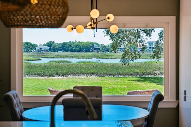 dining area with a water view and a chandelier