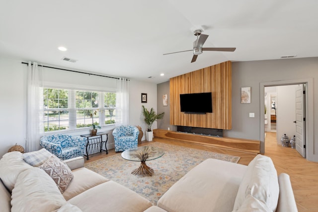 living room with vaulted ceiling, a ceiling fan, recessed lighting, and wood finished floors