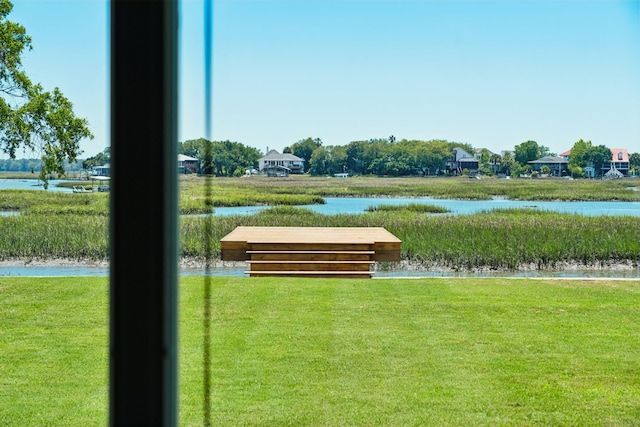view of home's community featuring a water view and a lawn