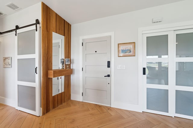 foyer featuring a barn door and baseboards