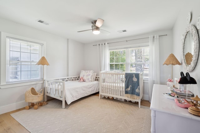 bedroom featuring baseboards, wood finished floors, and a ceiling fan