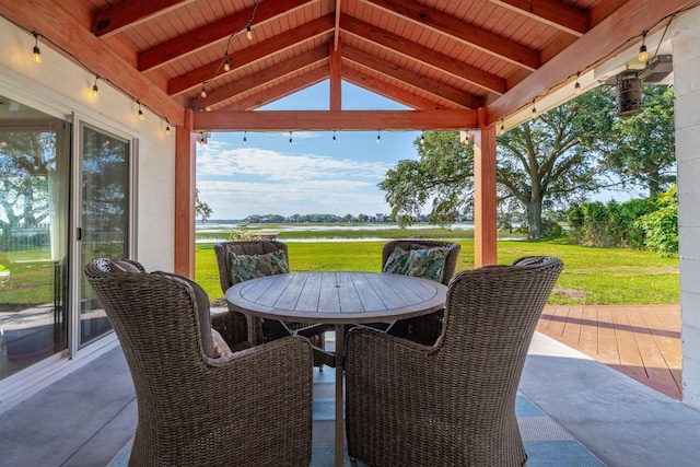 view of patio / terrace featuring outdoor dining space and a deck with water view