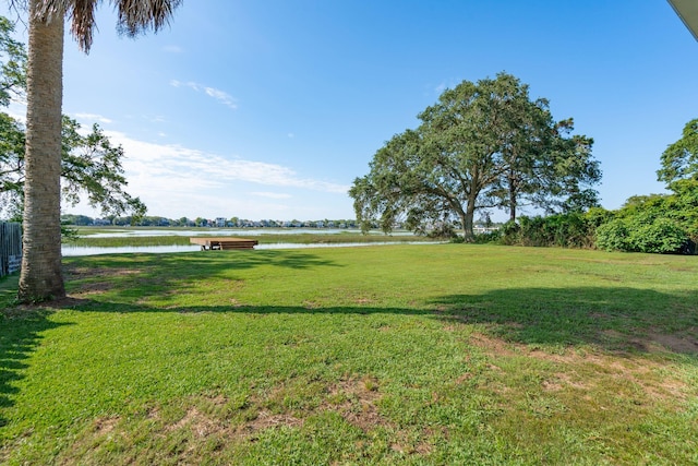 view of green lawn with a water view