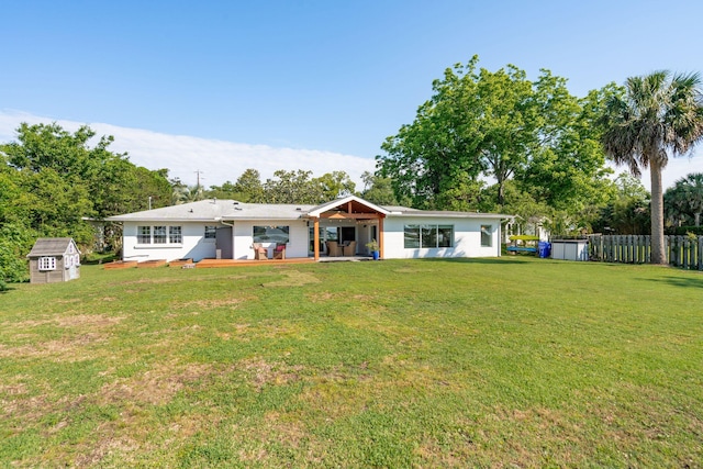 rear view of property with a shed, an outdoor structure, and a patio