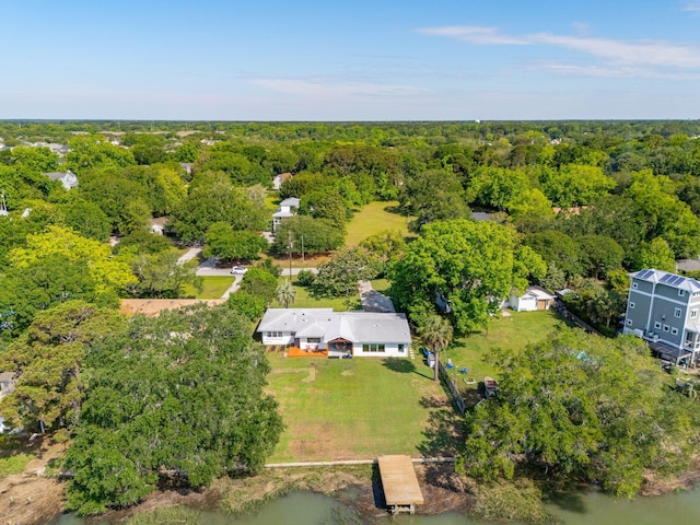 drone / aerial view of a large body of water and a heavily wooded area