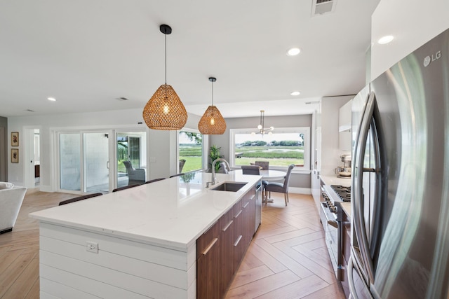 kitchen featuring stainless steel appliances, a sink, modern cabinets, a large island, and open floor plan