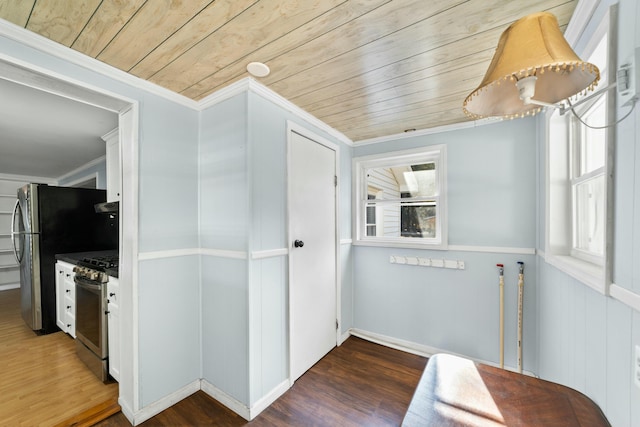 interior space featuring wooden ceiling, wood finished floors, stainless steel appliances, crown molding, and under cabinet range hood