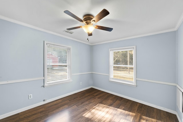 spare room with ceiling fan, wood finished floors, visible vents, baseboards, and crown molding