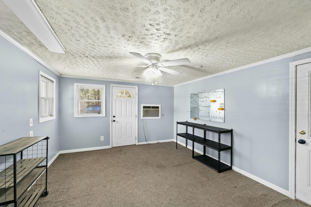 carpeted foyer entrance with ornamental molding, a textured ceiling, baseboards, and a ceiling fan