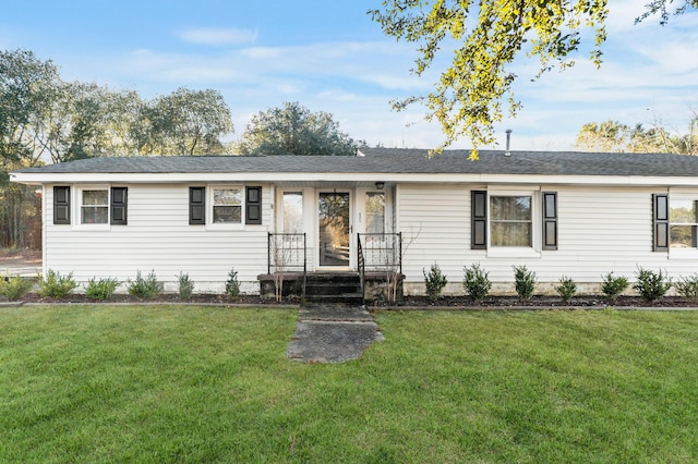 ranch-style house featuring a front lawn and a shingled roof