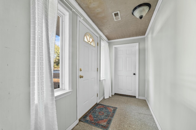 entryway with baseboards, visible vents, ornamental molding, a textured ceiling, and carpet floors