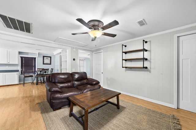 living area with attic access, visible vents, and light wood-style flooring