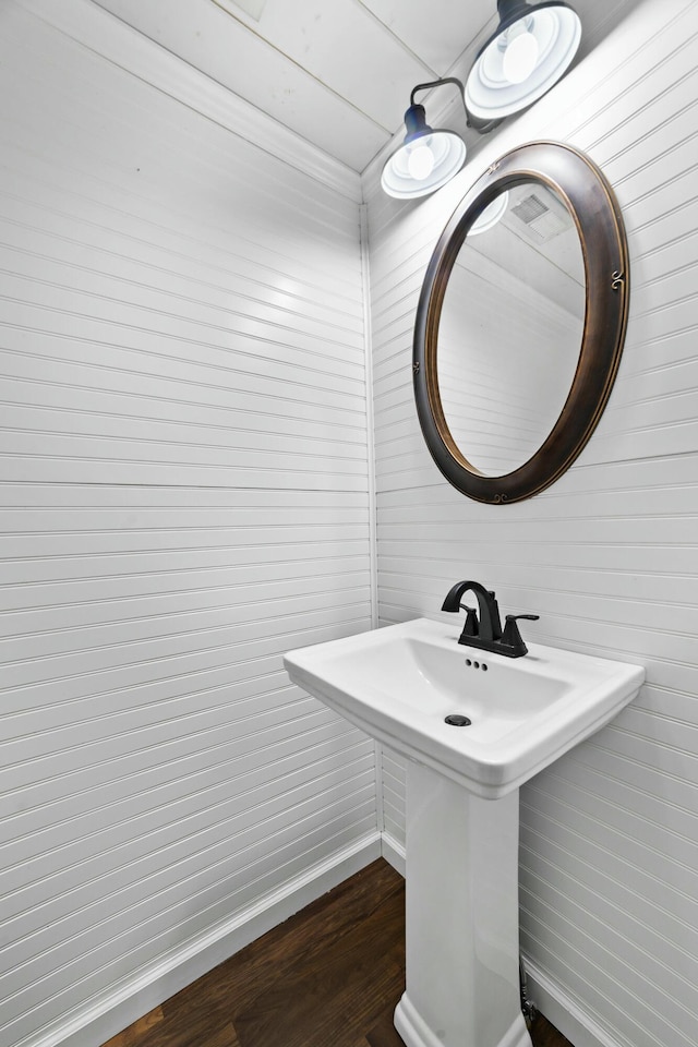 bathroom featuring a sink, wood finished floors, and baseboards