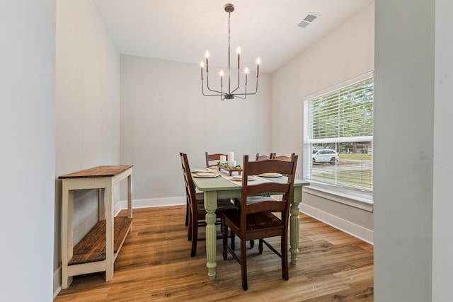 dining room with a chandelier, baseboards, and light wood-type flooring