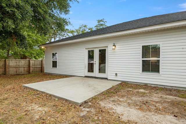 rear view of property featuring fence, a patio, and roof with shingles