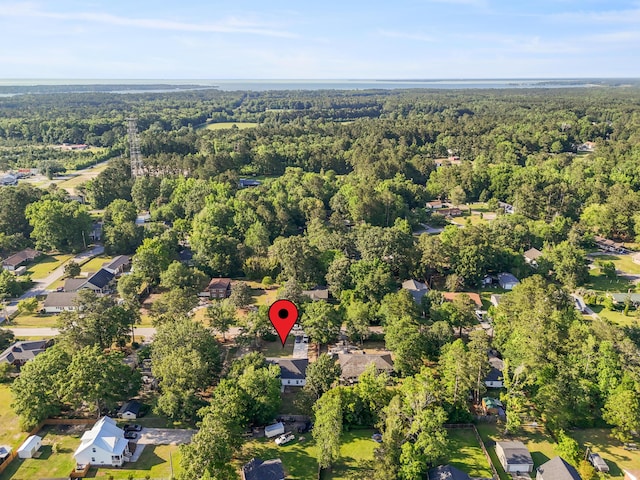aerial view of property's location featuring a heavily wooded area and nearby suburban area