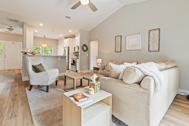 living area featuring ceiling fan, light wood finished floors, vaulted ceiling, baseboards, and recessed lighting