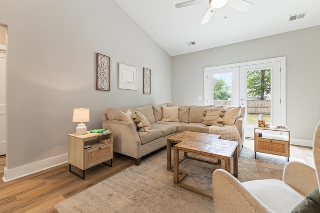 living room featuring vaulted ceiling, light wood finished floors, a ceiling fan, and baseboards