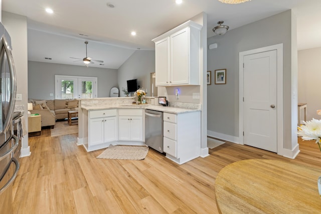 kitchen featuring appliances with stainless steel finishes, open floor plan, a peninsula, light wood finished floors, and white cabinetry