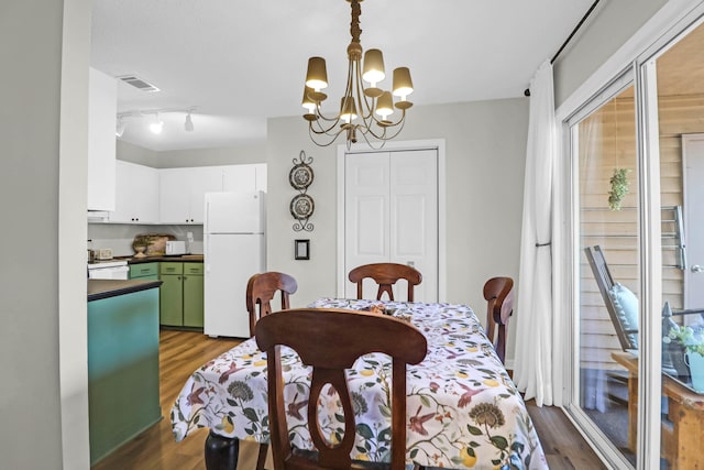 dining area featuring dark hardwood / wood-style flooring and a notable chandelier