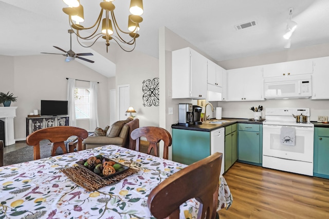 kitchen with sink, white appliances, hardwood / wood-style floors, white cabinets, and vaulted ceiling