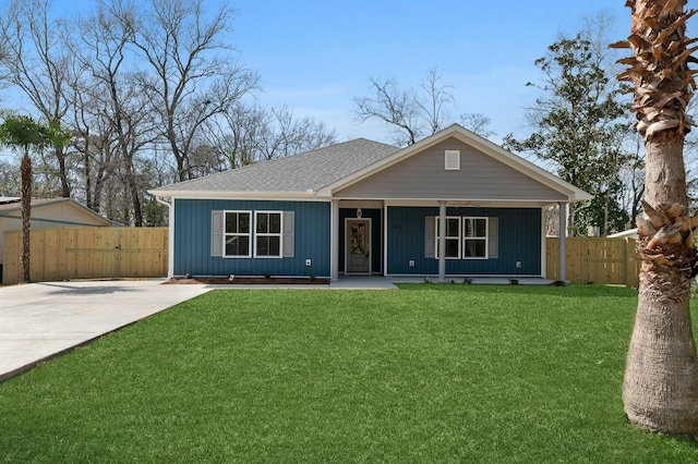 view of front facade featuring a porch, fence, a shingled roof, and a front lawn