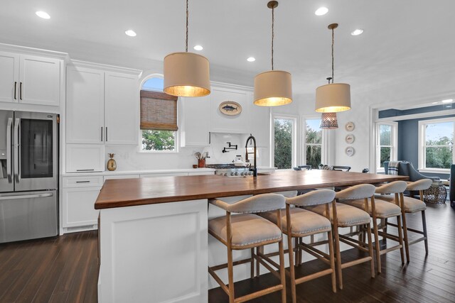 2128 Breezy Point Dr, Mount Pleasant, SC 29466 - kitchen featuring stainless steel refrigerator with ice dispenser, butcher block counters, a sink, dark wood-style floors, and an island with sink