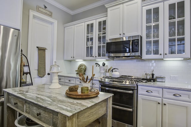 kitchen featuring light stone counters, ornamental molding, white cabinets, and appliances with stainless steel finishes