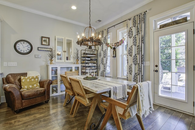 dining space with a notable chandelier, ornamental molding, and dark hardwood / wood-style floors