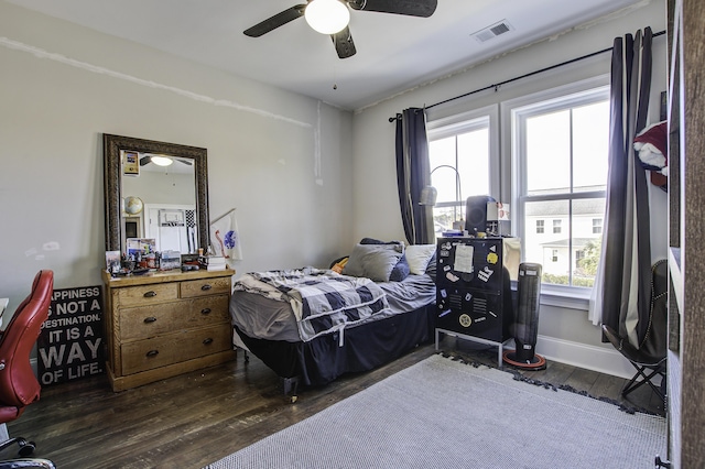 bedroom with multiple windows, ceiling fan, and dark hardwood / wood-style flooring